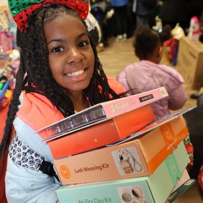 A girl holding a stack of wrapped gift boxes